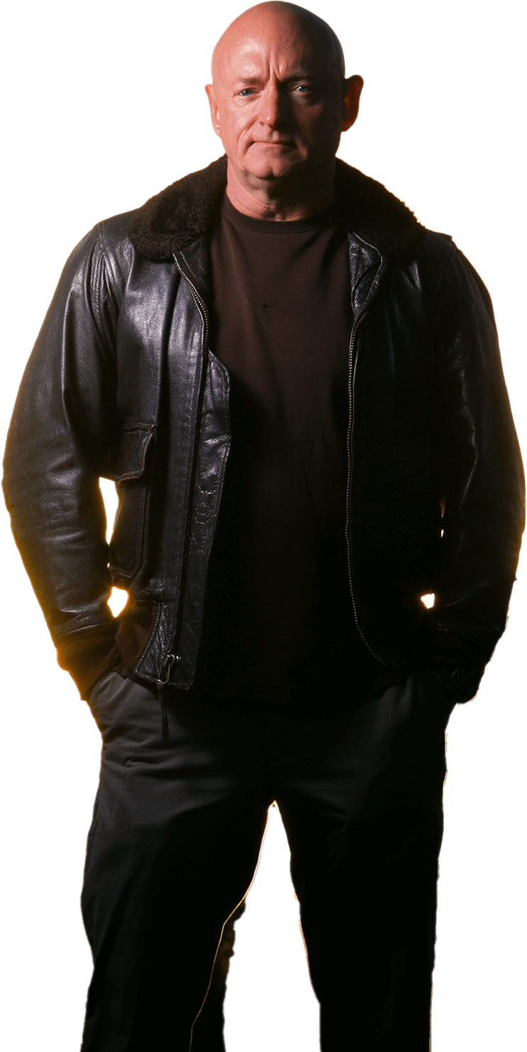 Mark Kelly standing in front of an airfield wearing a dark leather jacket