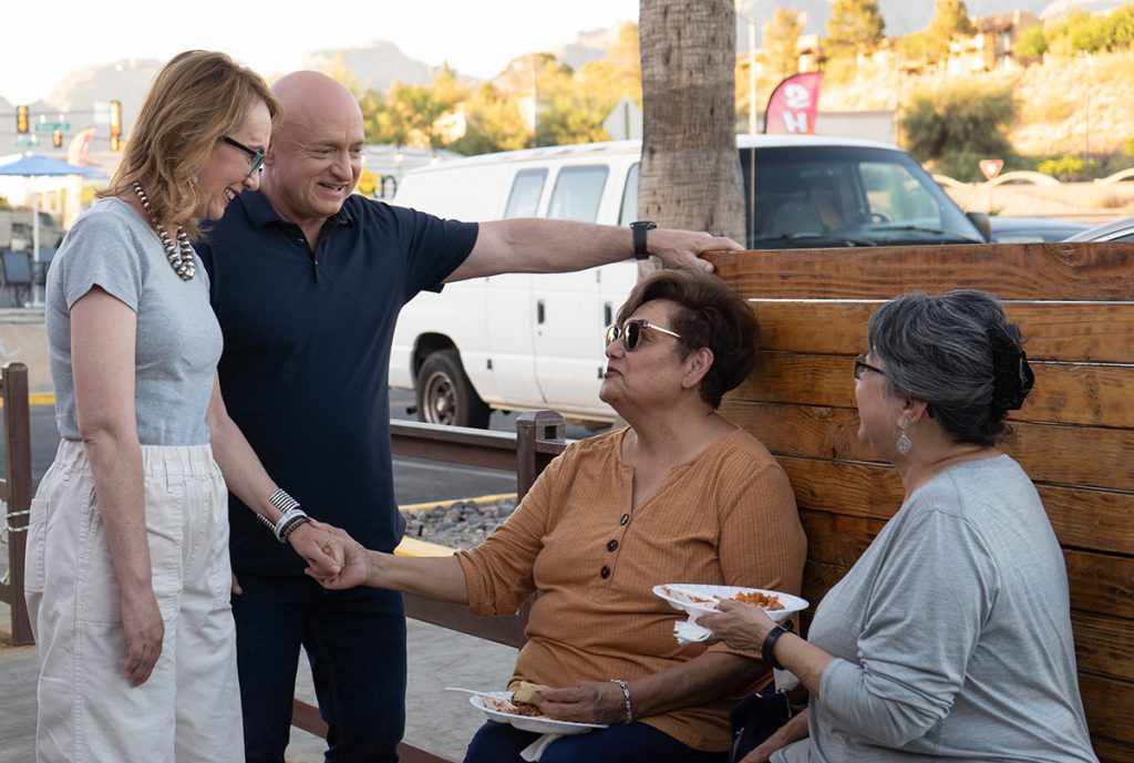 Mark Kelly and Gabby Giffords talk and laugh with two women outside of a local carniceria in Tucson, AZ.