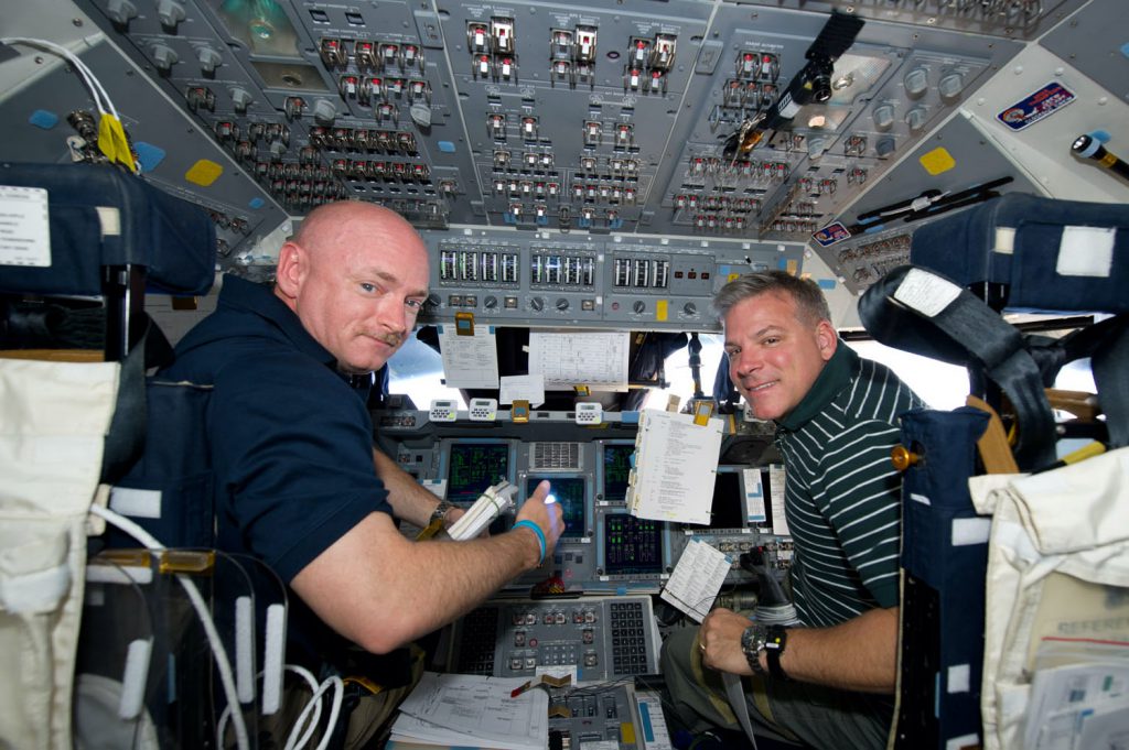 Mark Kelly sits in the commander’s seat of the Shuttle Endeavour while in orbit above Earth.